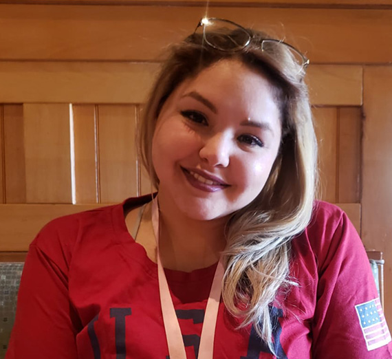 Wesley Schantz stands with students besides international flags in Gonzaga's Hemmingson Center. 